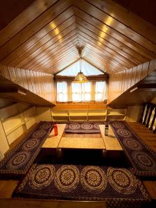 an attic room with a table and a window at Place To Reborn in Manāli
