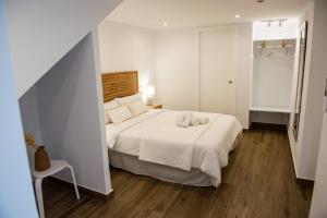 ein Schlafzimmer mit einem weißen Bett und einem Stuhl in der Unterkunft Torre Solana 41 in Cádiz
