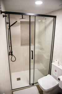 a glass shower in a bathroom with a toilet at Torre Solana 41 in Cádiz