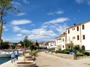 a group of people walking down a sidewalk next to a canal at Apartments Porat in Porat