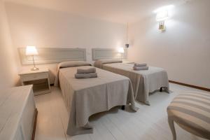 um quarto de hotel com duas camas com toalhas em Giardino al Mare em Forte dei Marmi