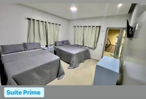 Habitación pequeña con 2 camas y mesa. en Casa Exclusive Salinas Atalaia, en Salinópolis