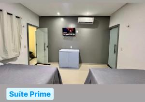 a room with two beds and a tv on the wall at Casa Exclusive Salinas Atalaia in Salinópolis