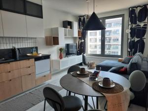 a kitchen and a living room with a table and chairs at APARTAMENTY Z MORZA I MARZEŃ in Gdynia
