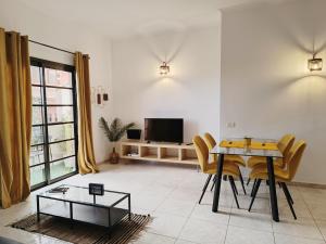 a living room with a table and chairs and a television at Diadas home in Guargacho