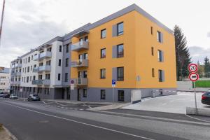 a yellow building on the side of a street at GRAY APARTMENT in Banská Bystrica