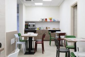 jadalnia ze stołami i zielonymi krzesłami w obiekcie Al Bacino Rooms And Breakfast w mieście Porto Viro