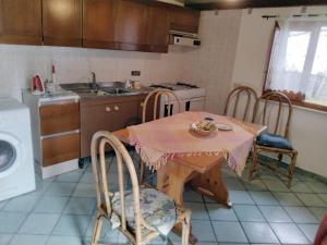 una cucina con tavolo, sedie e lavatrice di Il nido delle aquile a Pantelleria