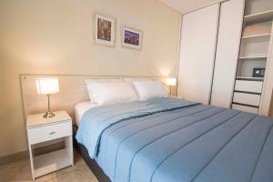 a bedroom with a blue bed and a night stand with a lamp at Apartment 1720 in Mendoza