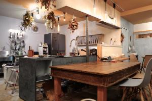 a large kitchen with a wooden table in it at すくもBOX in Sukumo