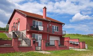 ein rotes Haus mit einem Kamin auf einem Hügel in der Unterkunft Villa Venezia in Egerszalók