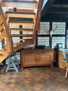 a kitchen with a wooden cabinet and stairs at Landhaus Reppel in Bad Laasphe