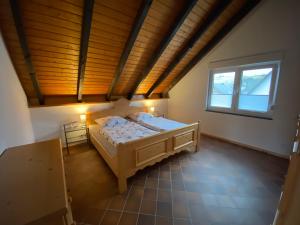 a bedroom with a bed and a wooden ceiling at Landhaus Reppel in Bad Laasphe