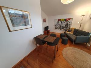 uma sala de estar com um sofá e uma mesa em Wohnung am Rhein, 20 Minuten von Bonn/ 45 Minuten von Köln. Möbliert perfekt für Wochenendfahrer/in em Königswinter