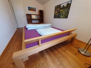 um quarto com uma cama de madeira num quarto em Wohnung am Rhein, 20 Minuten von Bonn/ 45 Minuten von Köln. Möbliert perfekt für Wochenendfahrer/in em Königswinter