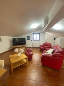 sala de estar con muebles de color rojo y TV de pantalla plana en Casa del Sole, en Foggia