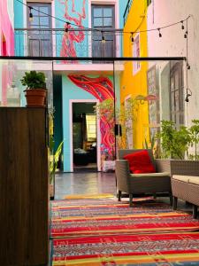 a patio with a couch and a colorful wall at Maison Verte - Budget Edition in Arequipa