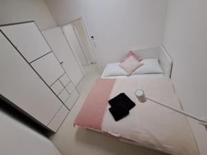 una piccola camera bianca con un letto e una lampada di Matea a Břeclav