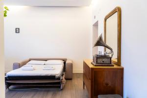 a bedroom with a bed and a mirror and a dresser at Regina Margherita Home in Rome
