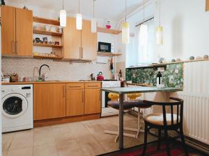 a kitchen with a table and a washing machine at Flat in historic villa with your own private garden, near City Park in Budapest