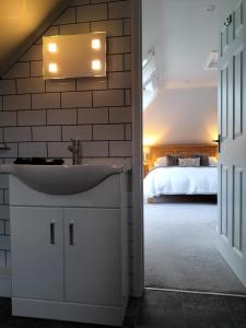 a bathroom with a sink and a bed in a room at Valley House in Exeter