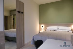 a bedroom with two beds and a table and a mirror at Al Bacino Rooms And Breakfast in Porto Viro