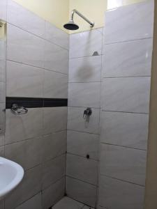 a bathroom with a shower with a sink at Epitome Times Hotel in Nairobi