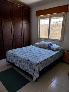 1 dormitorio con cama y ventana. en Casa da Totonha en São Lourenço do Sul