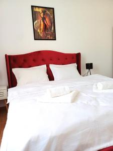 a large white bed with a red headboard at Bella Casa - ApartHotel in Dej