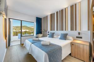 1 dormitorio con 2 camas y ventana grande en Hotel Vibra Beverly Playa en Paguera