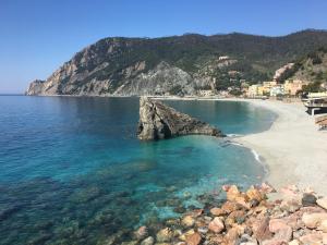 a beach with a rock sticking out of the water at Pae veciu camera privata con bagno in Monterosso al Mare