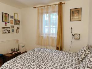 a bedroom with a bed and a window at Flat in historic villa with your own private garden, near City Park in Budapest