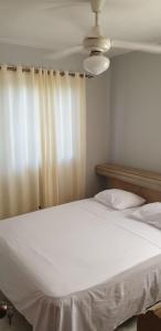 1 dormitorio con cama blanca y ventana en Clásico apartamento en Santo Domingo Este, en El Seis
