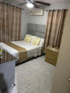 1 dormitorio pequeño con cama y cortinas en Clásico apartamento en Santo Domingo Este, en El Seis