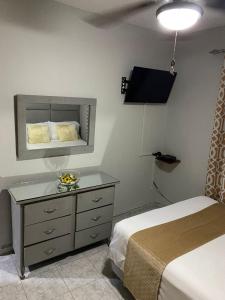 ein Schlafzimmer mit einem Bett und eine Kommode mit einem Spiegel in der Unterkunft Clásico apartamento en Santo Domingo Este in El Seis
