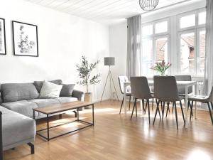 a living room with a couch and a table and chairs at *Ferienwohnung in Schwarzwald Villa für 6 Pers.* in Furtwangen