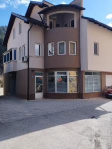 a large house with a driveway in front of it at Apartman Šljivo in Konjic