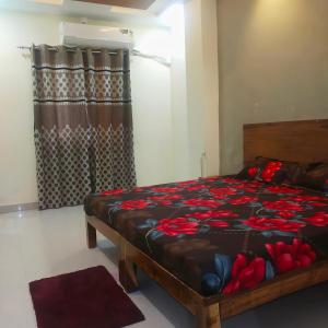 a bedroom with a bed with red flowers on it at Anant home stay in Ujjain