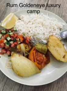 een witte plaat met rijst en groenten bij Rum Goldeneye luxury camp in Wadi Rum