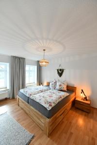 a bedroom with a large bed and a chandelier at Ferienwohnung am Altenlinderstall in Lindlar