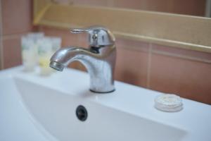 a bathroom sink with a faucet on top of it at Gess Hotel in Paramaribo