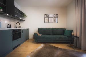 a living room with a green couch in a kitchen at GREEN APARTMENT in Banská Bystrica +6 photos