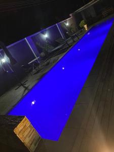 a blue swimming pool at night with tables and chairs at Luxurious Mangethe Suite - 2206 in Bulawayo