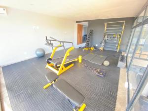 a gym with a yellow exercise bike and a treadmill at Luxurious Mangethe Suite - 2206 in Bulawayo