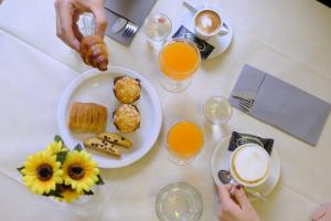 een tafel met een bord ontbijtproducten en jus d'orange bij Hotel Milano in Tolentino