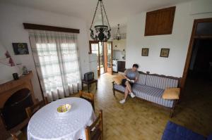 a man sitting on a couch in a living room at Elia Apartments Sithonia in Elia
