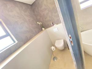 a bathroom with a toilet and a sink at Exquisite premium Fulatha Suite - 2202 in Bulawayo