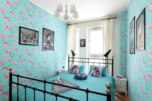 1 dormitorio con papel pintado de flores azul y rosa en Sleep Dream en Varsovia