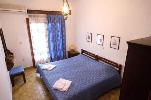 a bedroom with a blue bed with two towels on it at Elia Apartments Sithonia in Elia