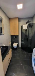 a bathroom with a shower and a toilet and a sink at Apartament Margaretville 90m in Kołobrzeg